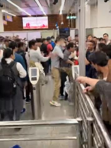 戴眼鏡男子見狀便從後面箍住灰衣男子前進。(網片截圖)