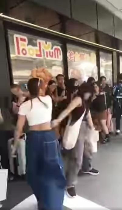 白衣女在指罵的同時發動攻擊,揮手打向黑衣女頭部。(網片截圖)