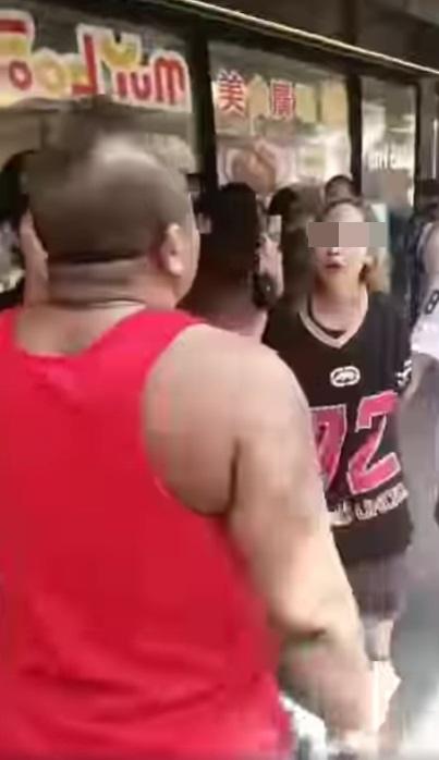 金髮女起身後不肯罷休,指罵其中一名紅衣壯漢。(網片截圖)