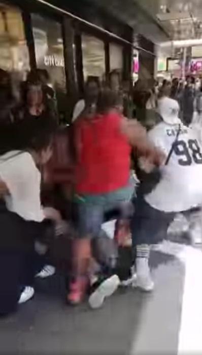 旁邊的兩名壯漢見狀,立即拉開金髮女,雙方打到在地上。(網片截圖)