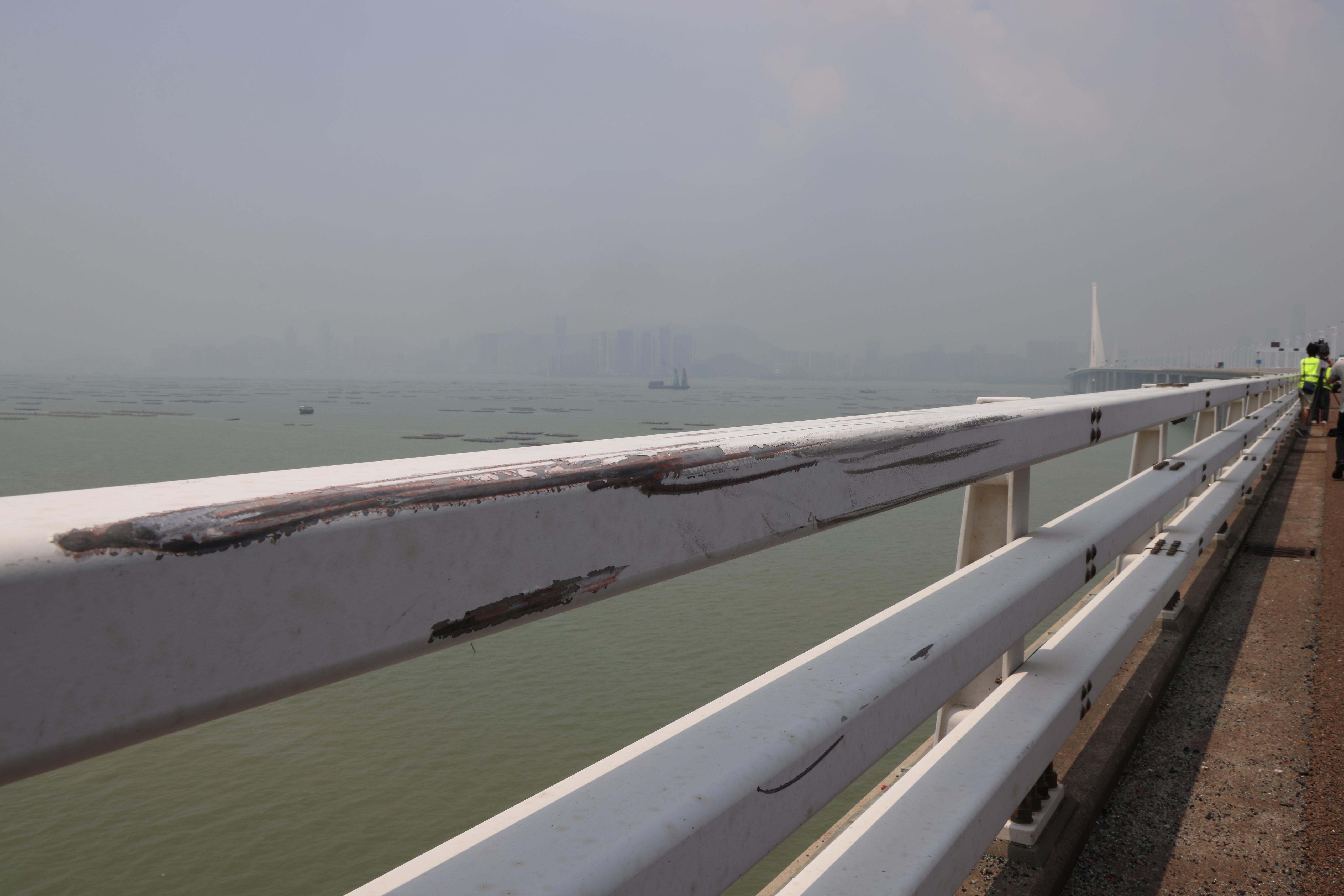 吊臂躉船在大橋附近的位置,用鋼纜把私家車由海中吊起,放上躉船運走。