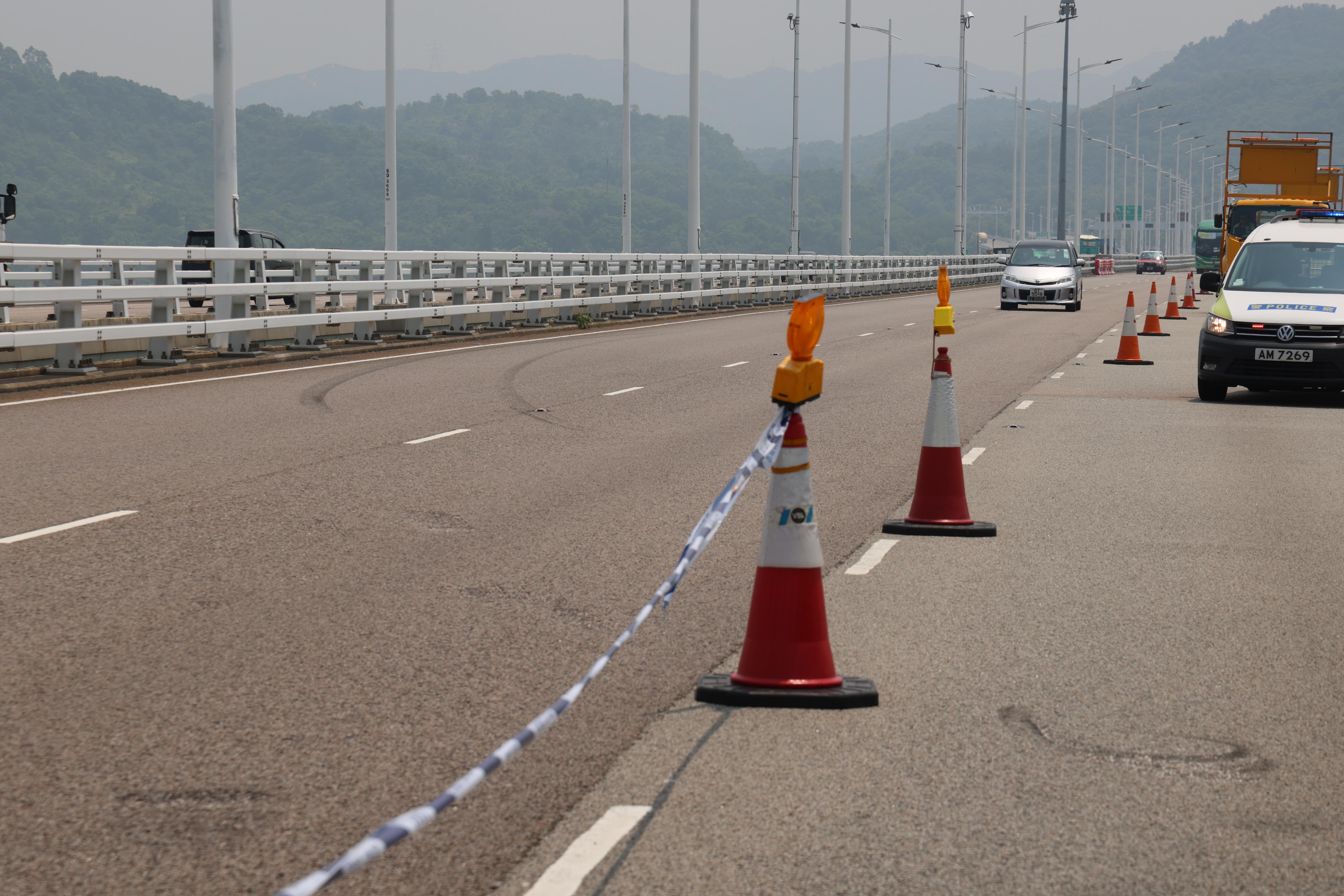 吊臂躉船在大橋附近的位置,用鋼纜把私家車由海中吊起,放上躉船運走。