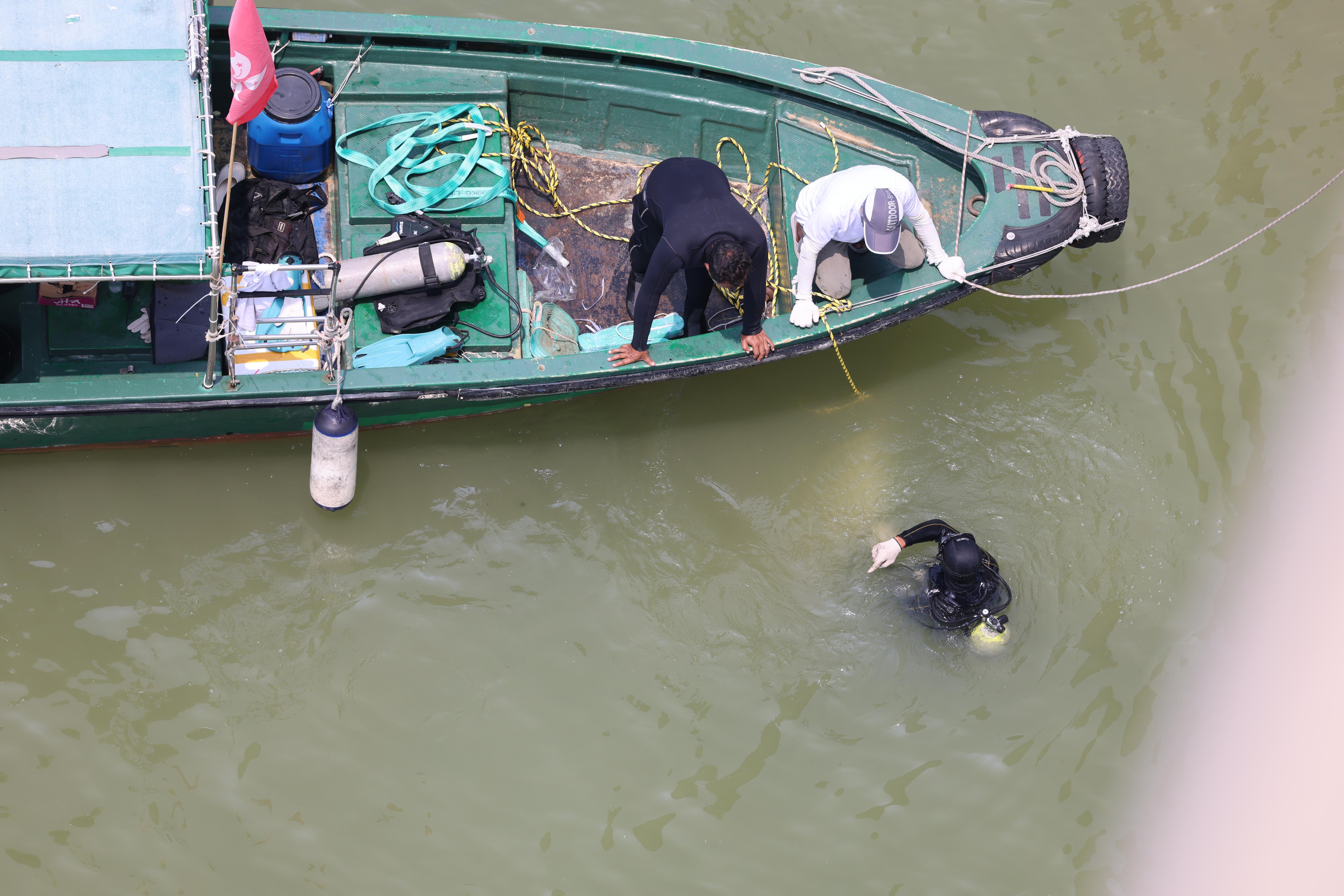 吊臂躉船在大橋附近的位置,用鋼纜把私家車由海中吊起,放上躉船運走。
