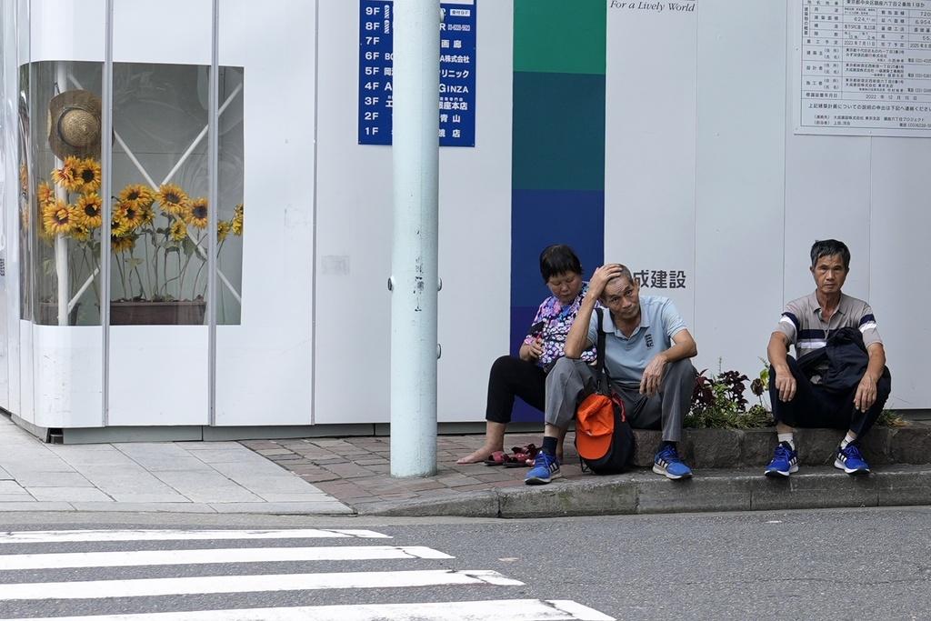 東京今夏炎熱。圖為上周有外國遊客坐在東京街道旁休息。(資料圖片)