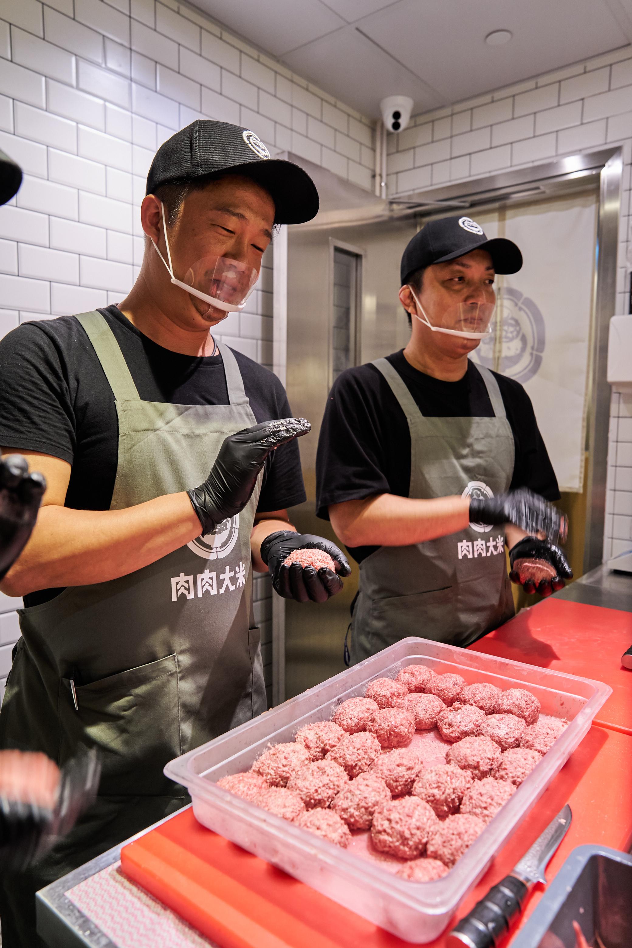 店員戴口罩和手套搓製漢堡。