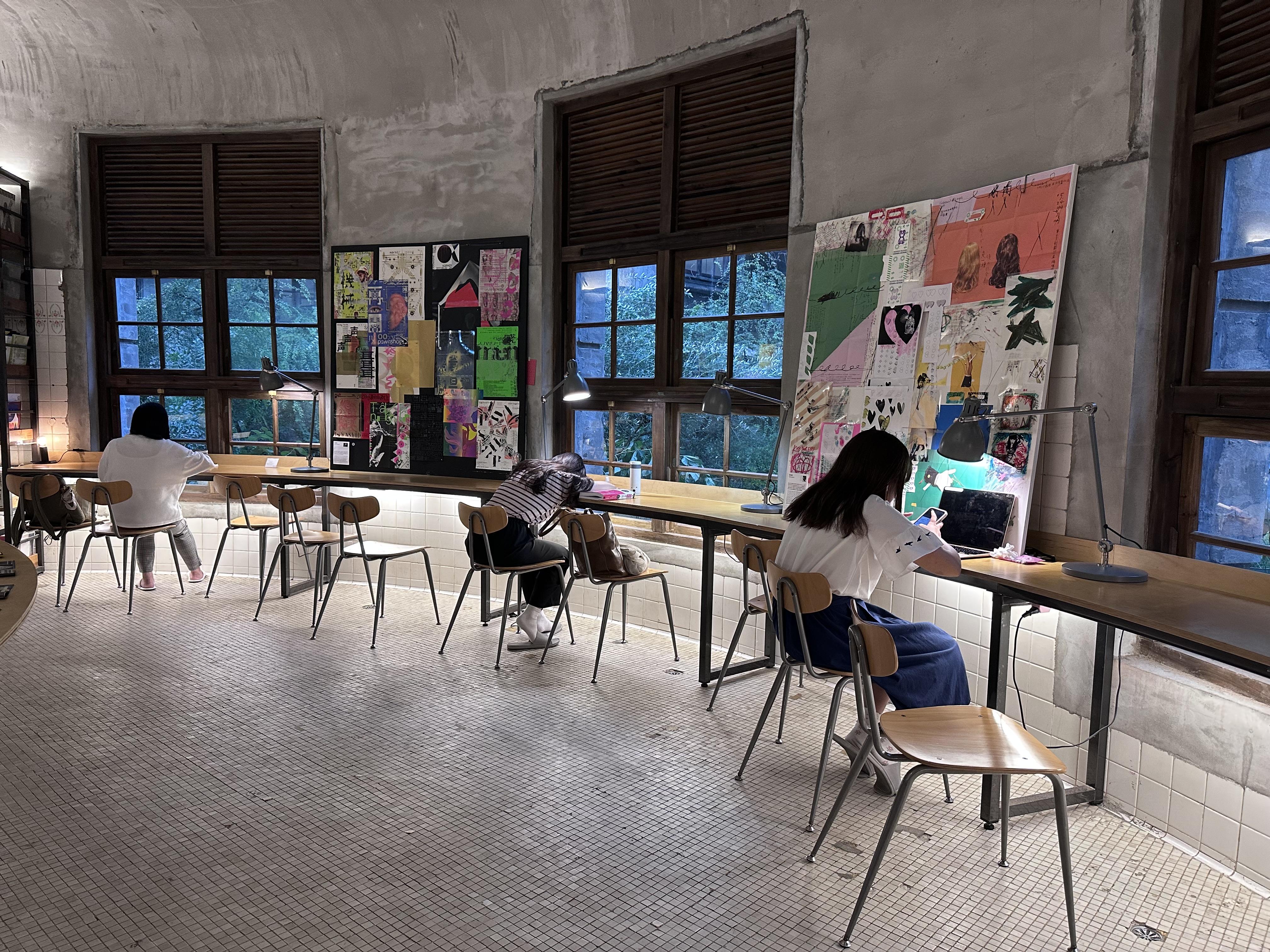 格子窗前的環形長書桌,跟窗外植物與灑落的陽光相互呼應。