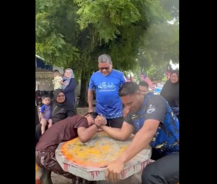 青年與大隻佬拗手瓜,出盡飲奶之力。(互聯網)