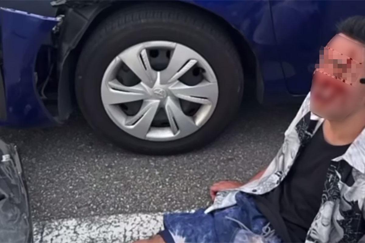 有港人在沖繩自駕遊發生交通意外,有人坐在車旁待救。(網上影片截圖)