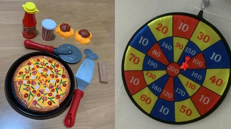 他射倒所有鋁罐後,為孩子贏得一套迷你廚房烹飪玩具和一個兒童飛鏢玩具