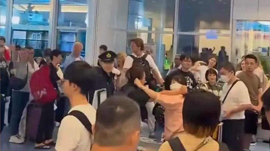 片段可見,兩名中國婦人在東京羽田機場大打出手,互扯耳朵,日本警察在旁勸交。(互聯網)