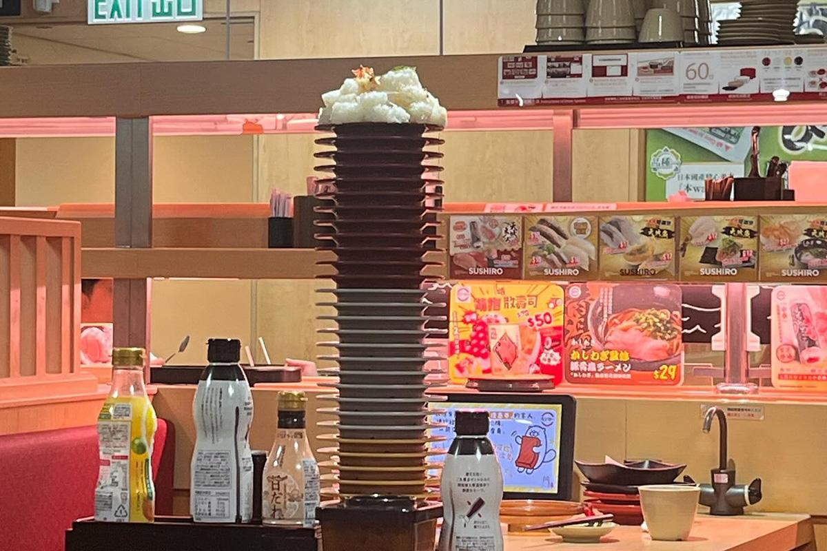 有壽司郎食客目擊鄰座「唔食飯」,並將之堆積在近30隻疊起的壽司碟上。(Threads圖片)