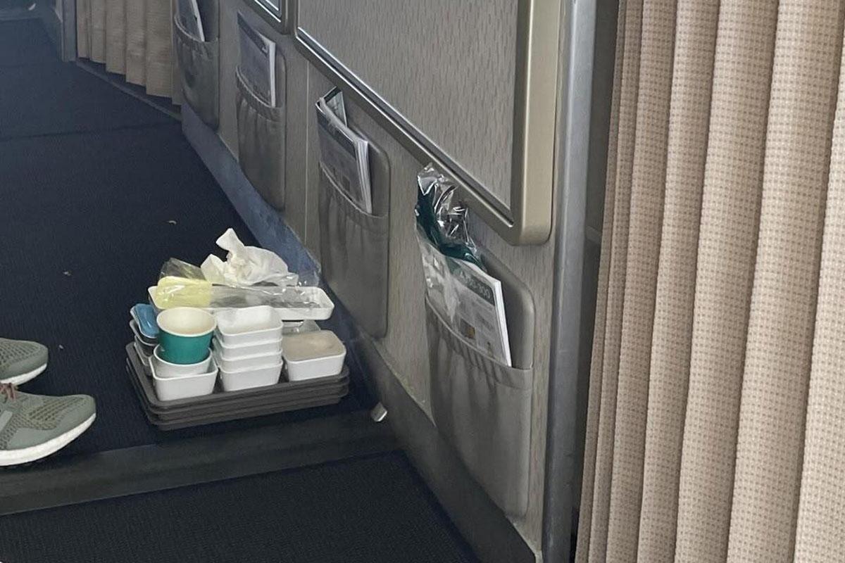 有飛機乘客發現有人把用過的飛機餐盒疊起待回收,在網上發帖分享。(Threads圖片)