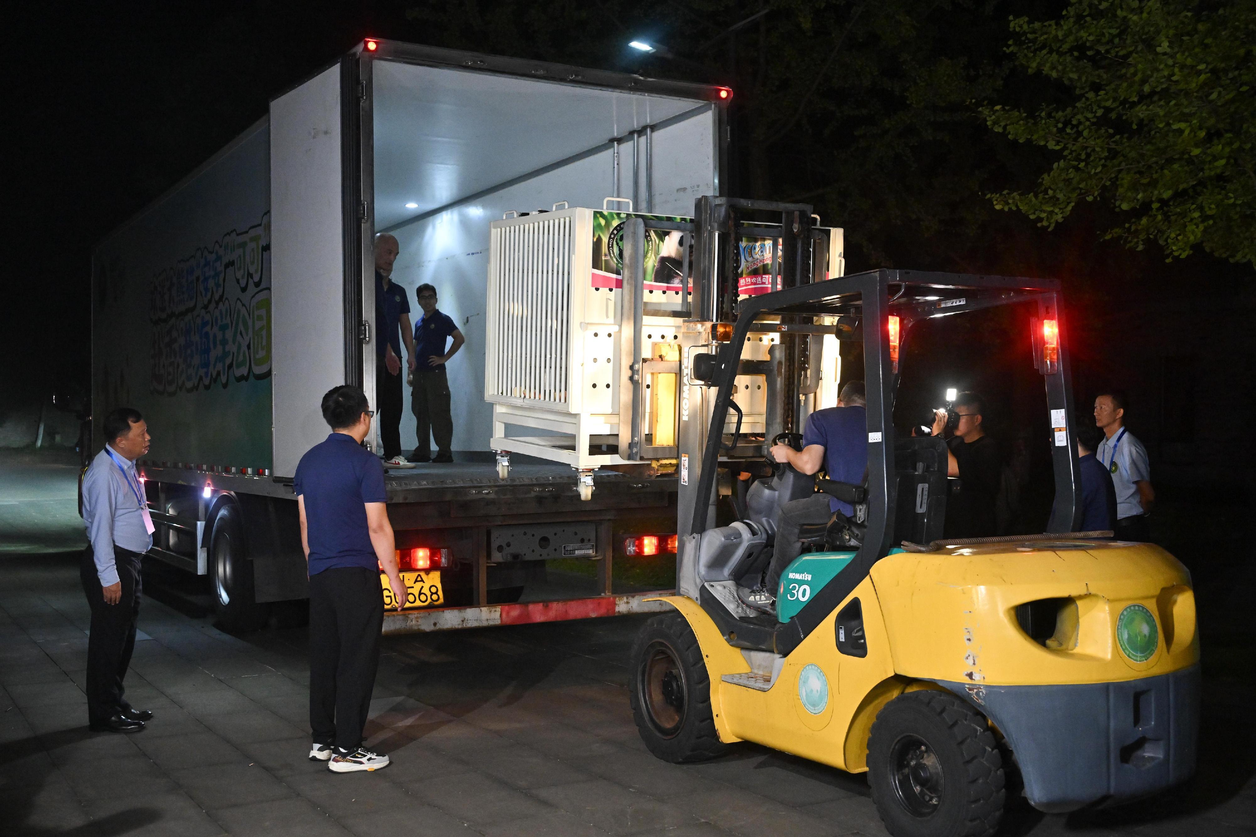 臨別在即,一批工作人員在路旁拉起橫額,舉起印有「安安」和「可可」的圖像牌送別,基地外有民眾專程來到與安安、可可道別。(政府新聞處)