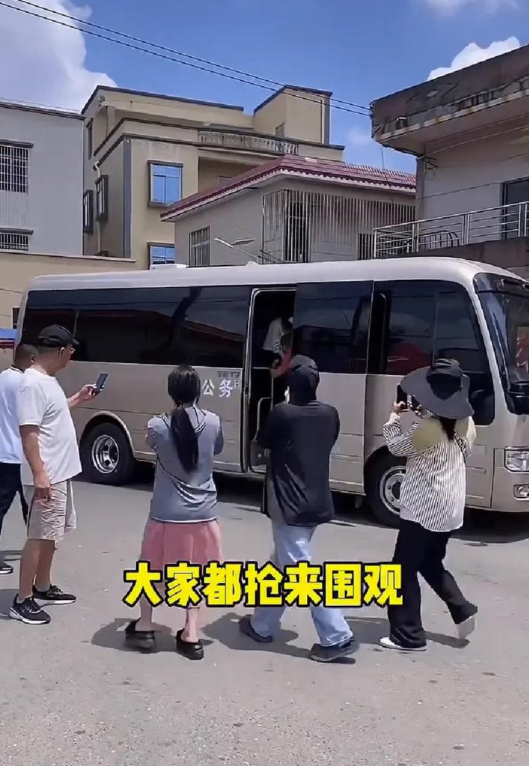 中型巴士駛到全紅嬋家門外,村民上前圍觀拍攝。(互聯網)