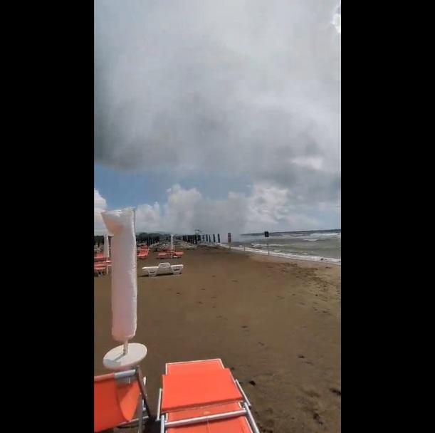巨大水龍捲移近太陽傘和沙灘椅。(互聯網)