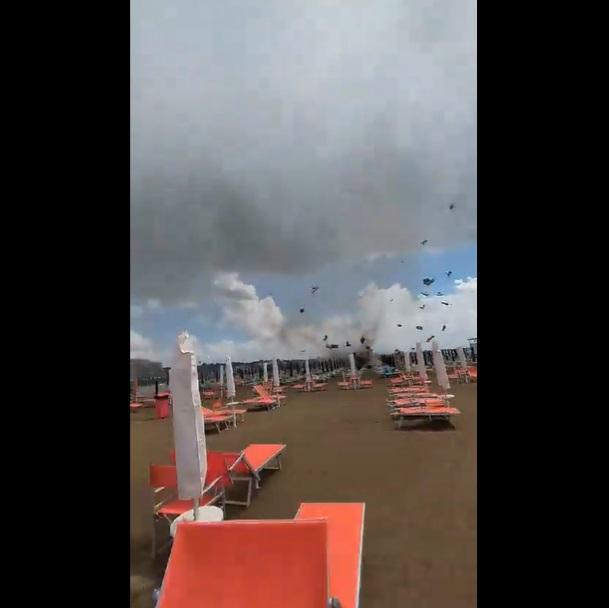 巨大水龍捲把太陽傘和沙灘椅等捲上半空。(互聯網)