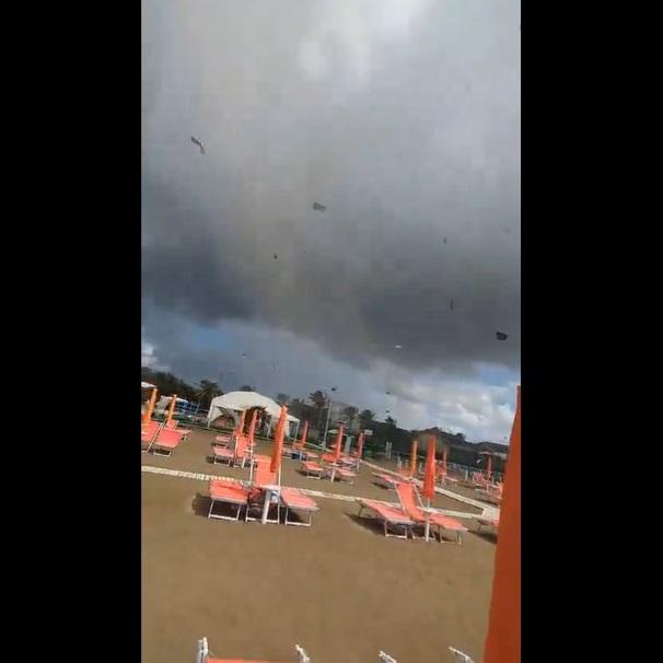 水龍捲橫掃沙灘,物件亂飛。(互聯網)