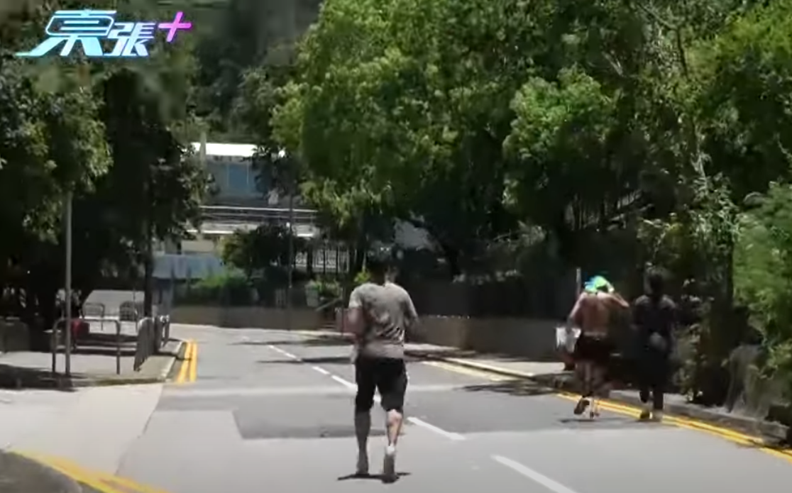 《東張西望》周一(7日)報道一名老翁於長沙灣李鄭屋邨球場內赤裸上身跑步,其後裸露下半身曬太陽,其中主持更與該名男子追逐。(影片截圖)