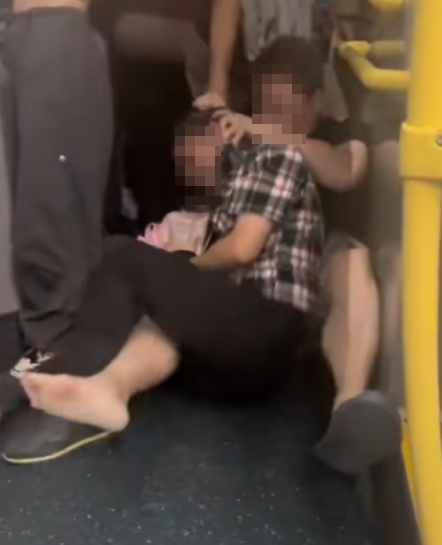 及後兩人在巴士通道地上扭鬥,格仔衫男仍落下風,被兩隻鞋飛脫的黑衣漢施以「奪命鉸剪腳」及緊扯頭髮鎖實。 (抖音影片截圖)