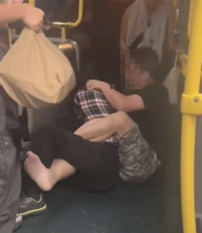 及後兩人在巴士通道地上扭鬥,格仔衫男仍落下風,被兩隻鞋飛脫的黑衣漢施以「奪命鉸剪腳」及緊扯頭髮鎖實。 (抖音影片截圖)