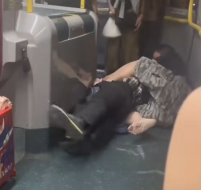 及後兩人在巴士通道地上扭鬥,格仔衫男仍落下風,被兩隻鞋飛脫的黑衣漢施以「奪命鉸剪腳」及緊扯頭髮鎖實。 (抖音影片截圖)