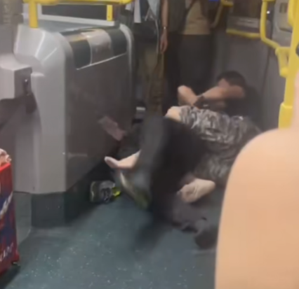 及後兩人在巴士通道地上扭鬥,格仔衫男仍落下風,被兩隻鞋飛脫的黑衣漢施以「奪命鉸剪腳」及緊扯頭髮鎖實。 (抖音影片截圖)