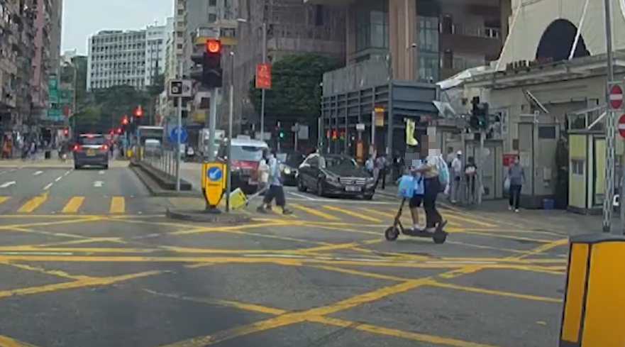油麻地一名男子駕駛電動滑板車載着一名女童,於十字路掟彎逆線「任我行」。(車CAM特警YouTube)