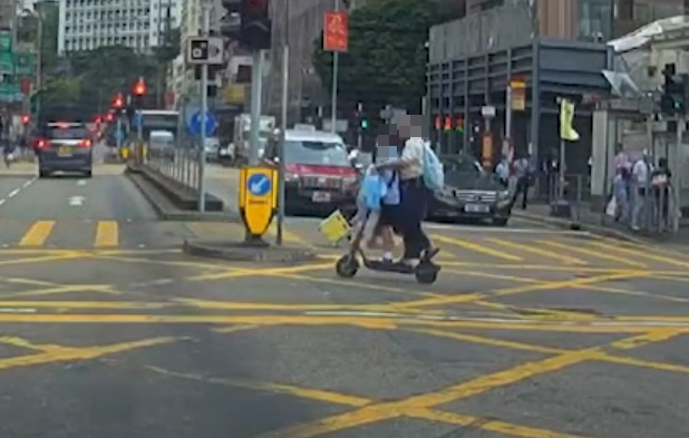油麻地一名男子駕駛電動滑板車載着一名女童,於十字路掟彎逆線「任我行」。(車CAM特警YouTube)