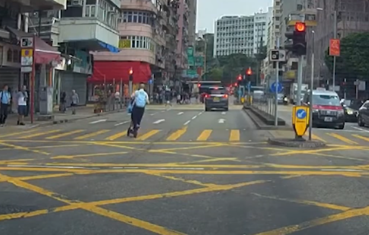 油麻地一名男子駕駛電動滑板車載着一名女童,於十字路掟彎逆線「任我行」。(車CAM特警YouTube)