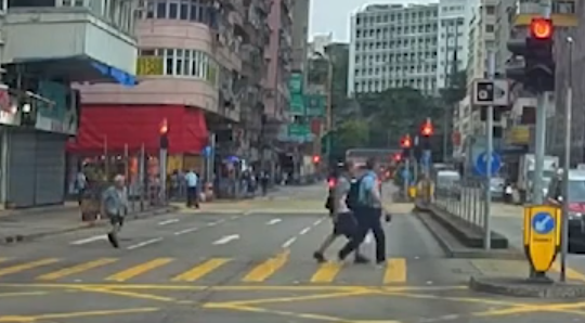 油麻地一名男子駕駛電動滑板車載着一名女童,於十字路掟彎逆線「任我行」。(車CAM特警YouTube)