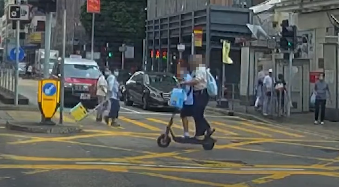 油麻地一名男子駕駛電動滑板車載着一名女童,於十字路掟彎逆線「任我行」。(車CAM特警YouTube)