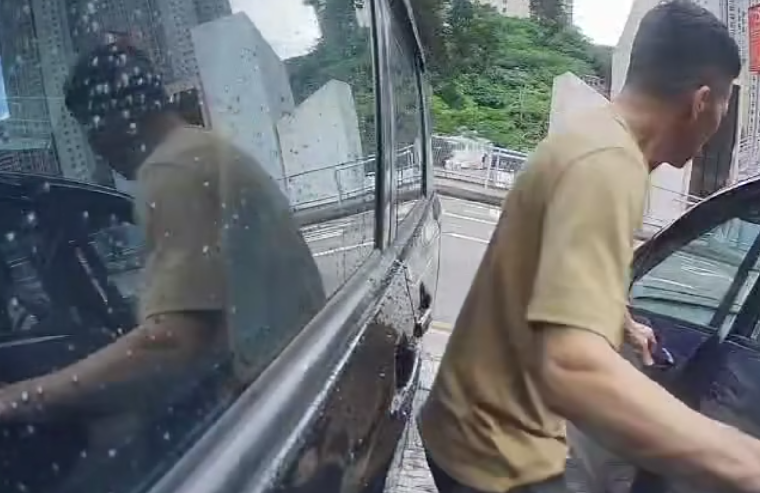 一名中年男子於葵涌走入兩車車罅,大力打開藍色私家車車門,猛撞泊在旁邊的黑色私家車車身,整個過程被黑色私家車的車cam拍下。(影片截圖)