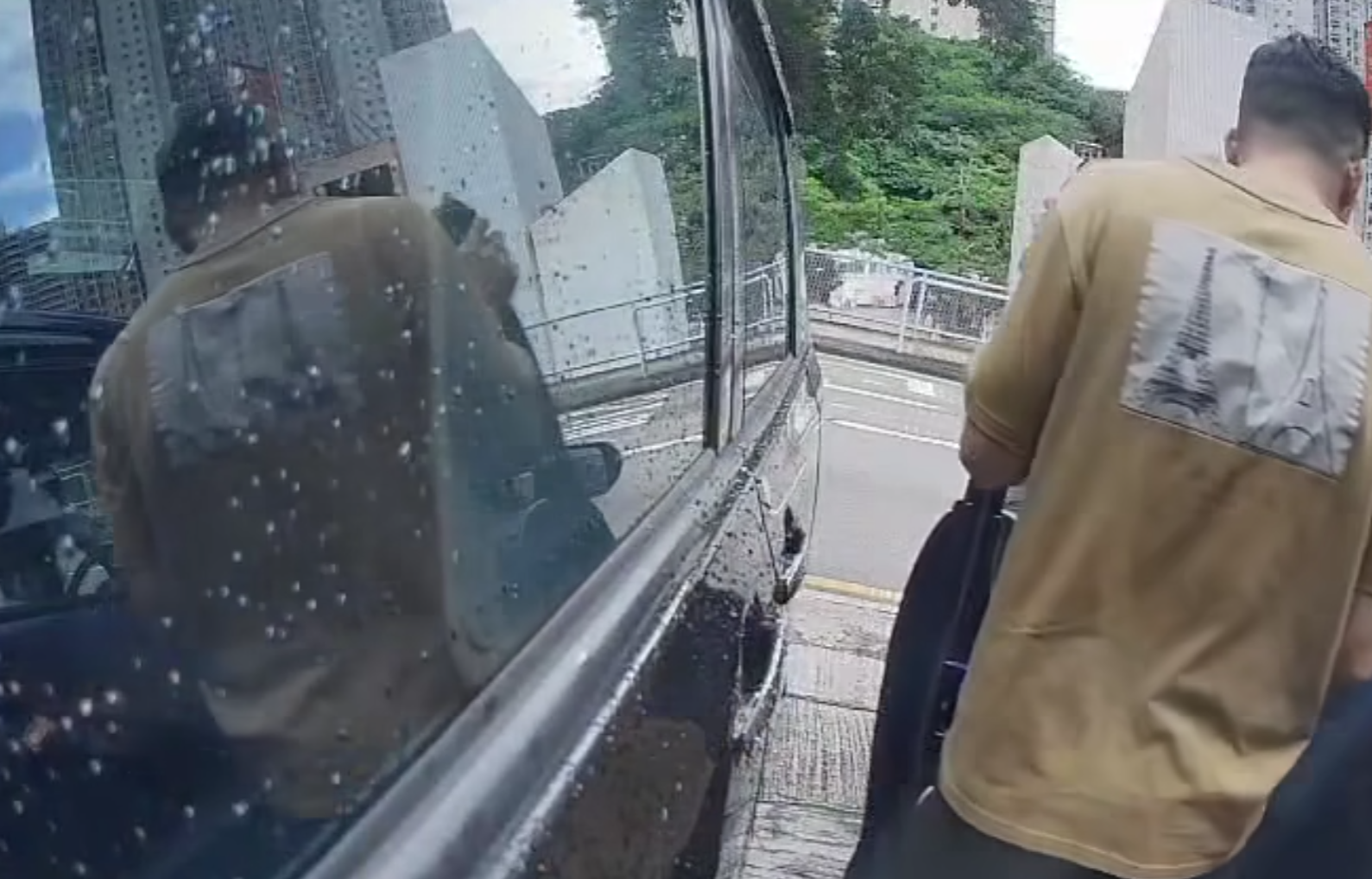 一名中年男子於葵涌走入兩車車罅,大力打開藍色私家車車門,猛撞泊在旁邊的黑色私家車車身,整個過程被黑色私家車的車cam拍下。(影片截圖)