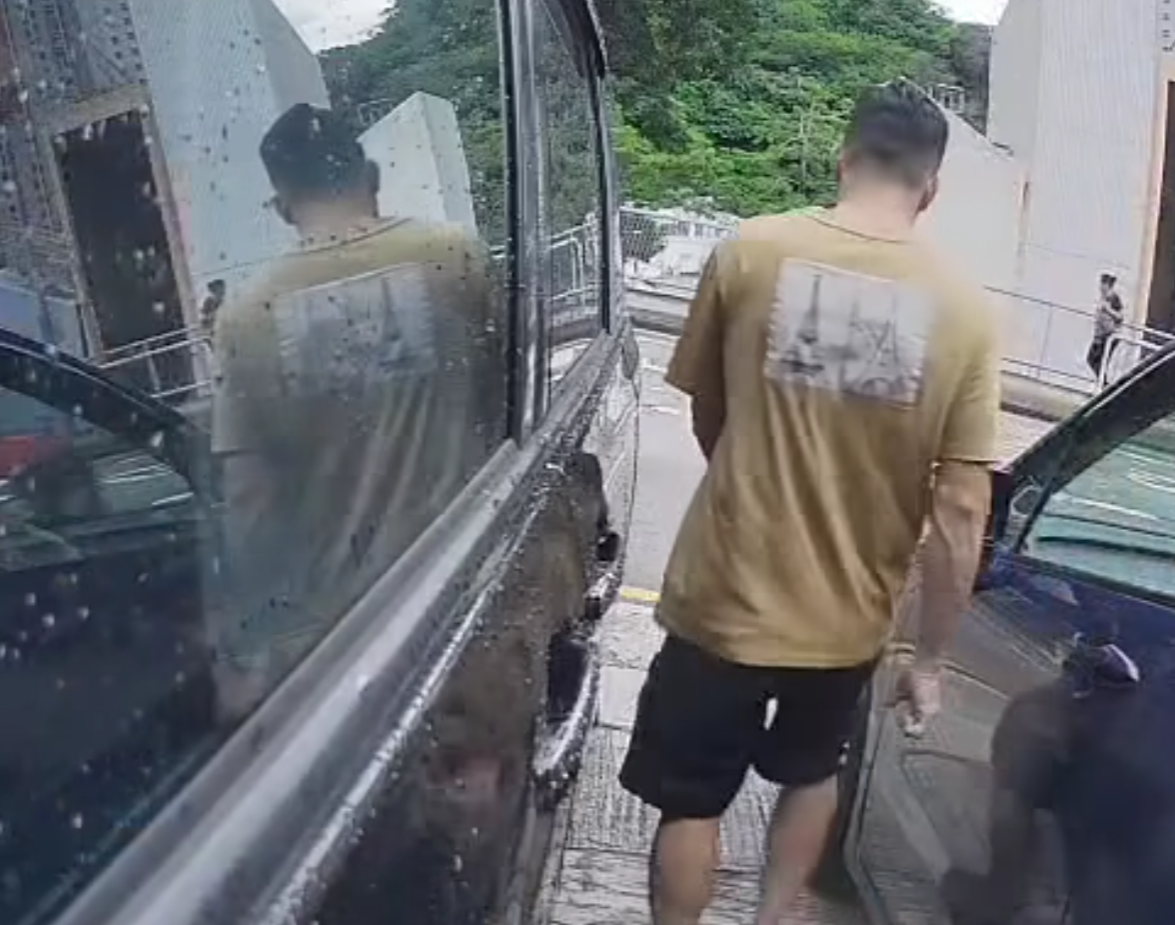 一名中年男子於葵涌走入兩車車罅,大力打開藍色私家車車門,猛撞泊在旁邊的黑色私家車車身,整個過程被黑色私家車的車cam拍下。(影片截圖)