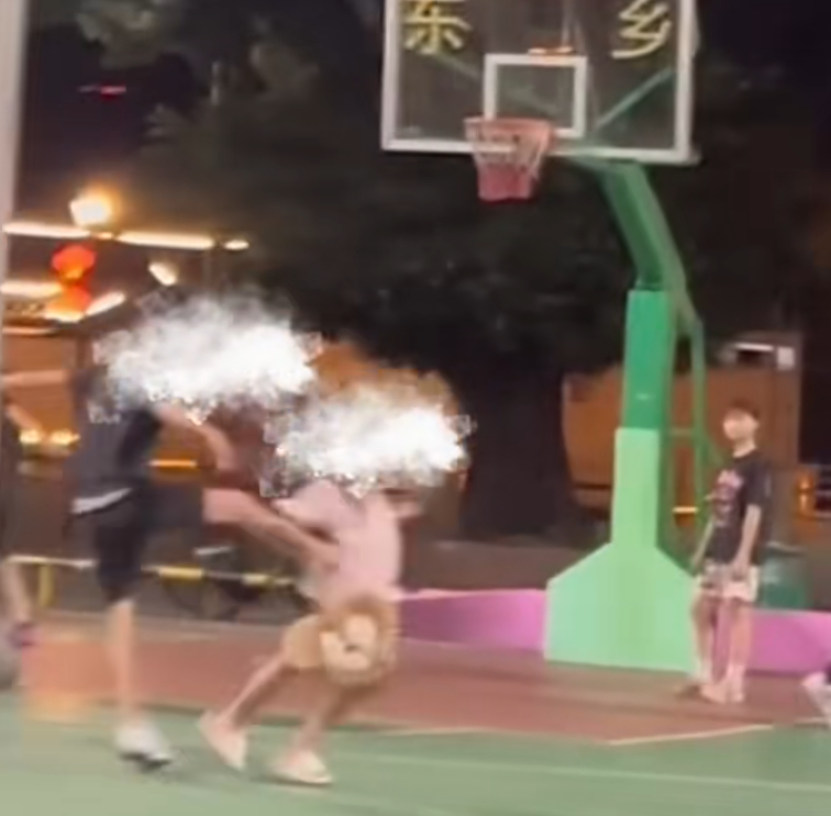 一名穿黑衣短褲的少年於籃球場急步助跑數步,飛身朝前方步行的一名穿粉色衫少女飛踢。(影片截圖)