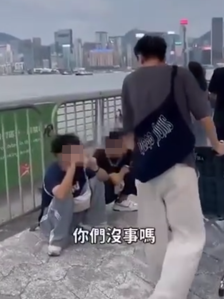 兩名香港網紅稱對很多遊客來到「踎低」感到不解,嘲諷他們是否腰骨有問題,手推輪椅往尖沙咀星光大道用普通話詢問多名蹲在地上的遊客:「我看你蹲了好久,是不是腰骨有問題,要不要坐輪椅?」(影片截圖)
