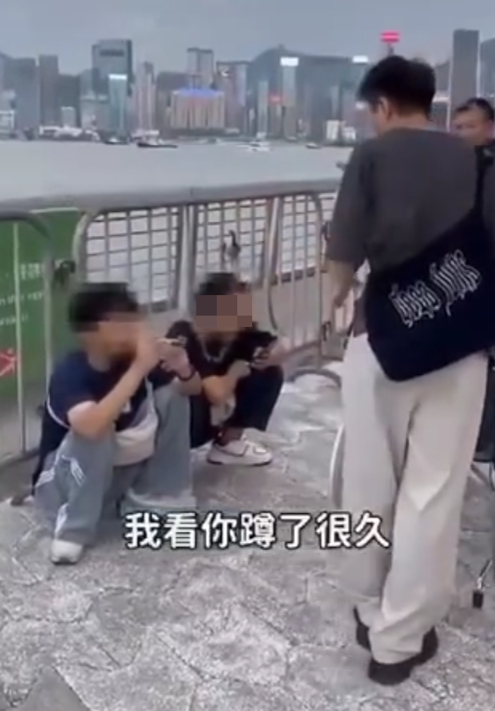 兩名香港網紅稱對很多遊客來到「踎低」感到不解,嘲諷他們是否腰骨有問題,手推輪椅往尖沙咀星光大道用普通話詢問多名蹲在地上的遊客:「我看你蹲了好久,是不是腰骨有問題,要不要坐輪椅?」(影片截圖)
