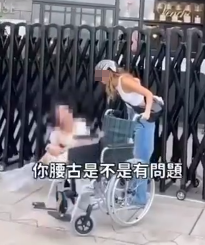 兩名香港網紅稱對很多遊客來到「踎低」感到不解,嘲諷他們是否腰骨有問題,手推輪椅往尖沙咀星光大道用普通話詢問多名蹲在地上的遊客:「我看你蹲了好久,是不是腰骨有問題,要不要坐輪椅?」(影片截圖)