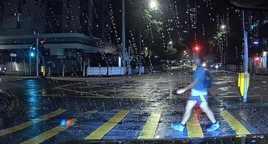 身穿淺藍衣短褲的背包中年男子由車頭右至左過馬路(facebook群組「大埔人大埔谷」)