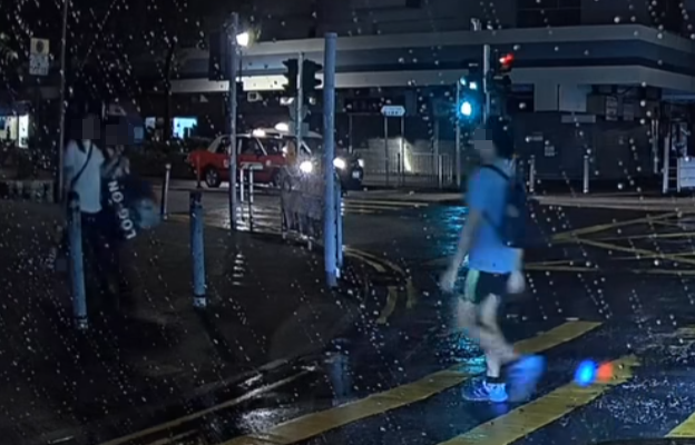 兩名少女同撐一傘正由另一方向行人路走出準備過路(facebook群組「大埔人大埔谷」)