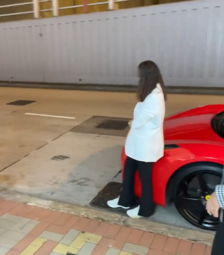 旺角亞皆老街街頭停泊一輛紅色法拉利,吸引不少內地大媽圍着打卡拍照,有人甚至半挨靠在車頭冚位置 (Threads影片截圖)