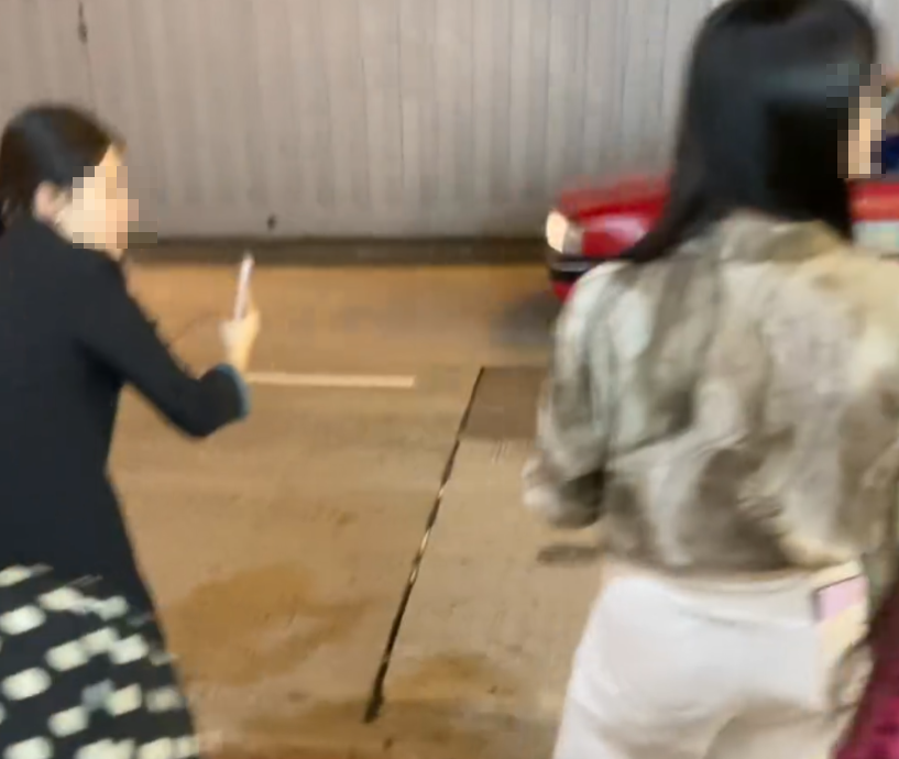 旺角亞皆老街街頭停泊一輛紅色法拉利,吸引不少內地大媽圍着打卡拍照,有人甚至半挨靠在車頭冚位置 (Threads影片截圖)