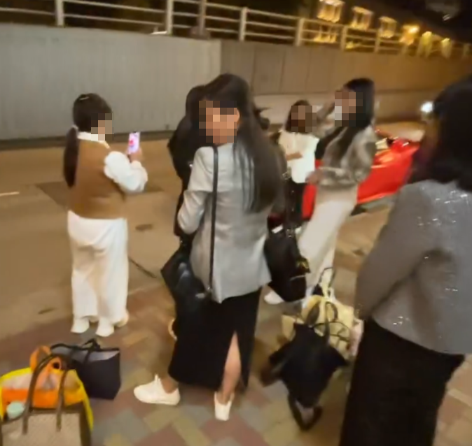 旺角亞皆老街街頭停泊一輛紅色法拉利,吸引不少內地大媽圍着打卡拍照,有人甚至半挨靠在車頭冚位置 (Threads影片截圖)