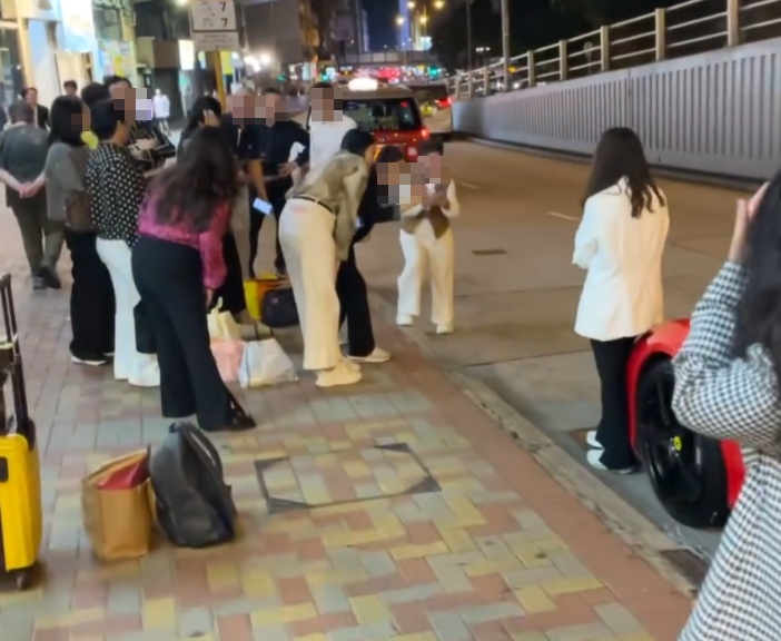 旺角亞皆老街街頭停泊一輛紅色法拉利,吸引不少內地大媽圍着打卡拍照,有人甚至半挨靠在車頭冚位置 (Threads影片截圖)