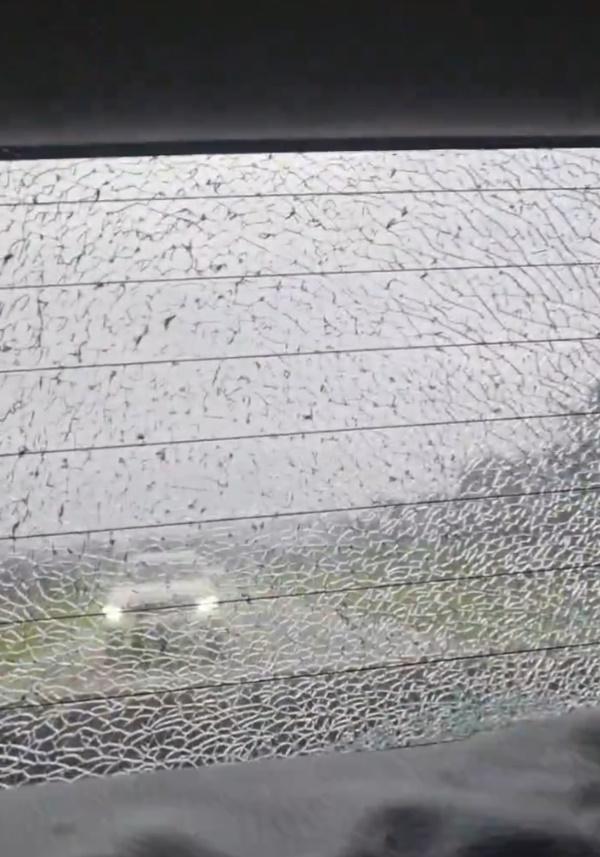 車尾檔風玻璃破裂,後方有一輛白色車輛尾隨。(X)