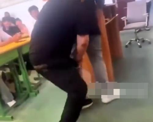 片中教師用力將羽毛球拍柄桶向學生屁股。(微博)