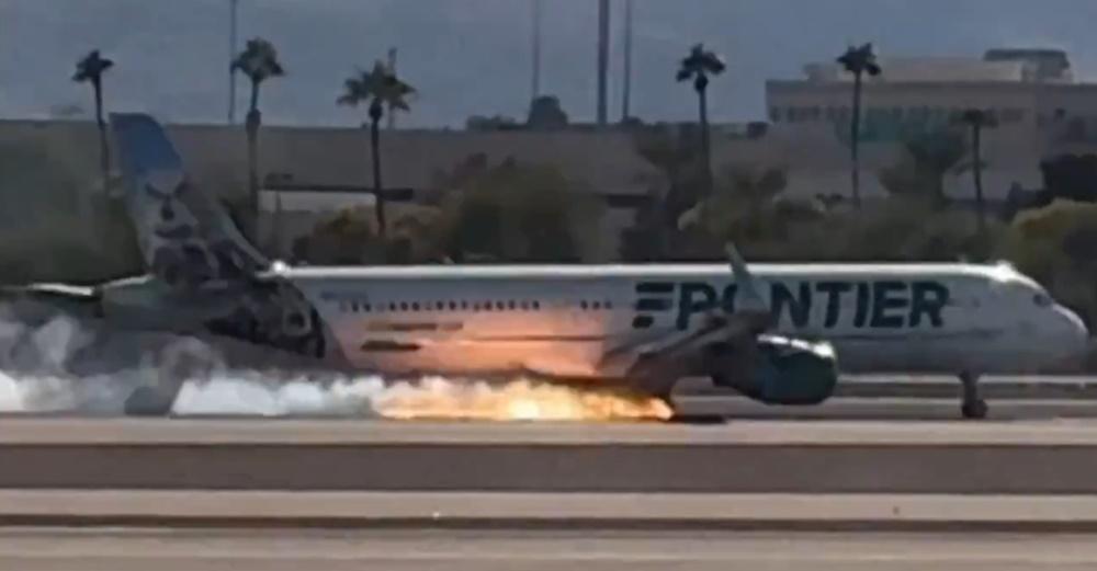 機場跑道上,飛機觸地後,起落架冒出長長火焰和煙霧。(X)