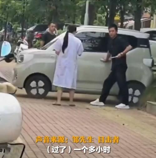 疑似車主在一旁看著電動車一直倒車,車輪在地上不停摩擦,反應尷尬。(微博)
