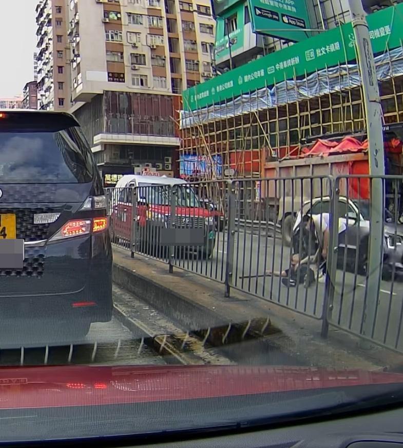 白衣男試圖拉起黑衣男,惟黑衣男堅持「𦧲地」不起。(網片截圖)