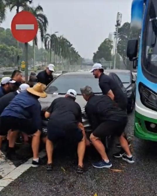 近十名遊客合力抬走擋路的車輛。